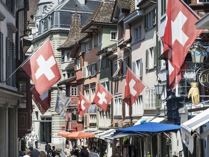 Flags of Switzerland hanging on buildings near Sternen Oerlikon