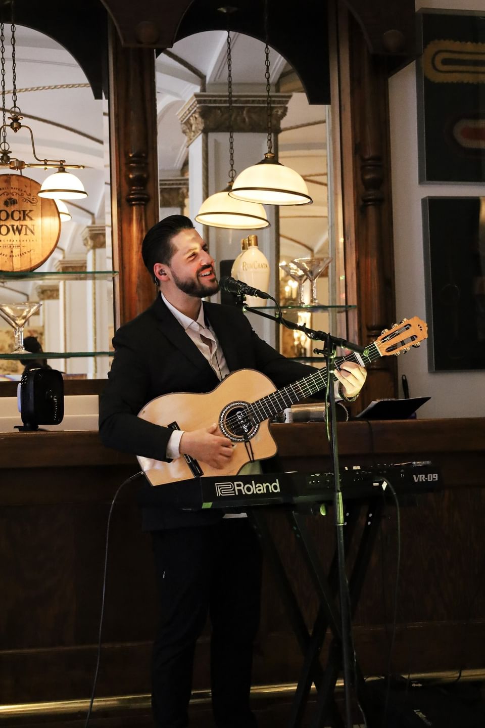Guitarist by a wooden bar under warm pendant lights in a social lounge at Arlington Resort Hotel & Spa