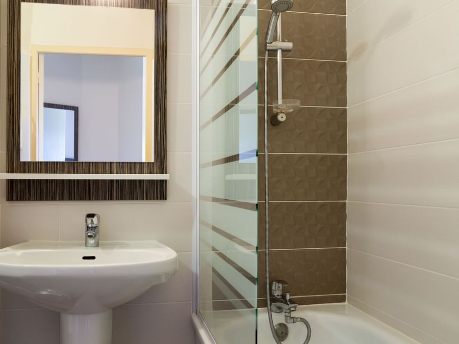 Bathroom bathtub & vanity area at Hotel L'Acropole