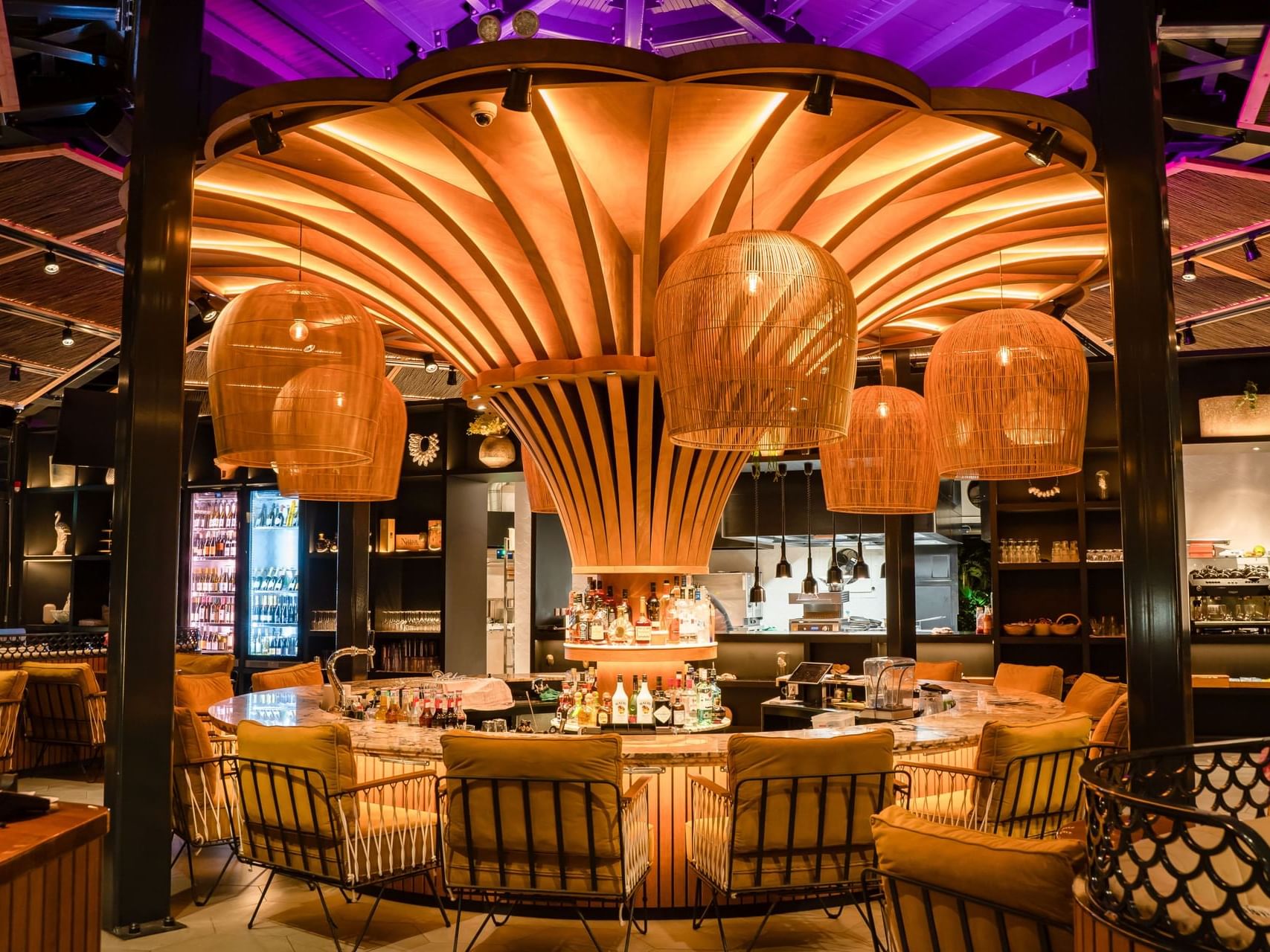 Bar interior featuring a circular marble counter, wooden ceiling accent in the Breeze Restaurant at Golden Rock Resort