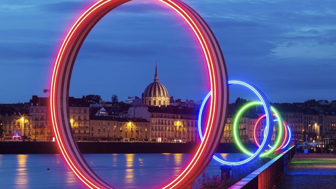 Colorful lights encircling the river at night near Oceania Hotels