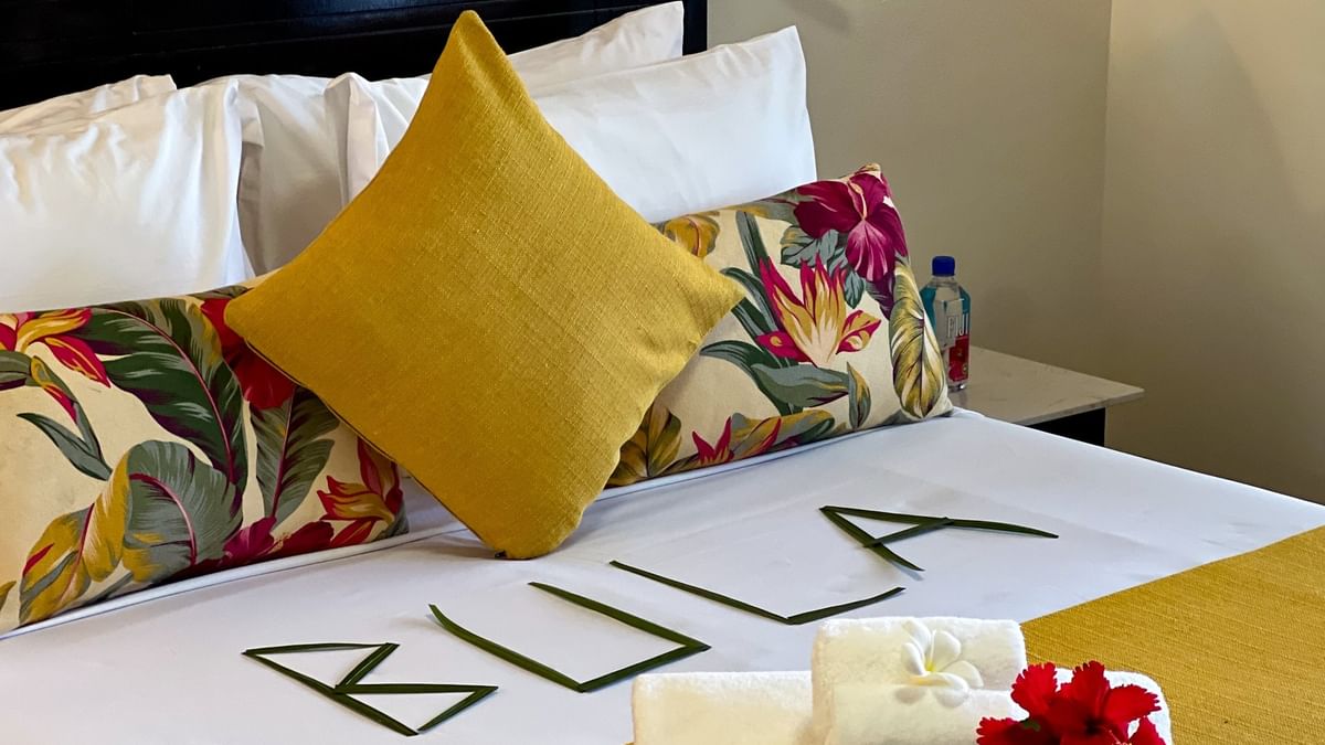 Standard Room at Tokatoka Resort, Nadi, with a bed, floral pillows, and a yellow bedspread.