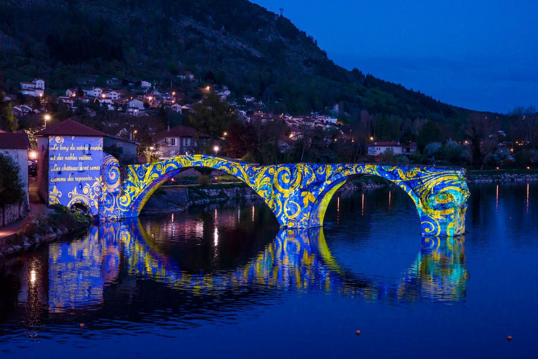 A bridge decroated with colorful lights near a river in Bristol