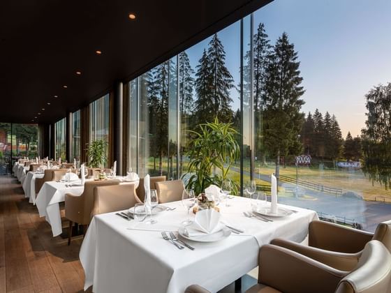 Altitude Restaurant with dining tables and large windows at Ana Hotels Sport Poiana Brașov