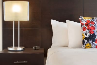 une lampe sur une table de chevet à côté d'un lit