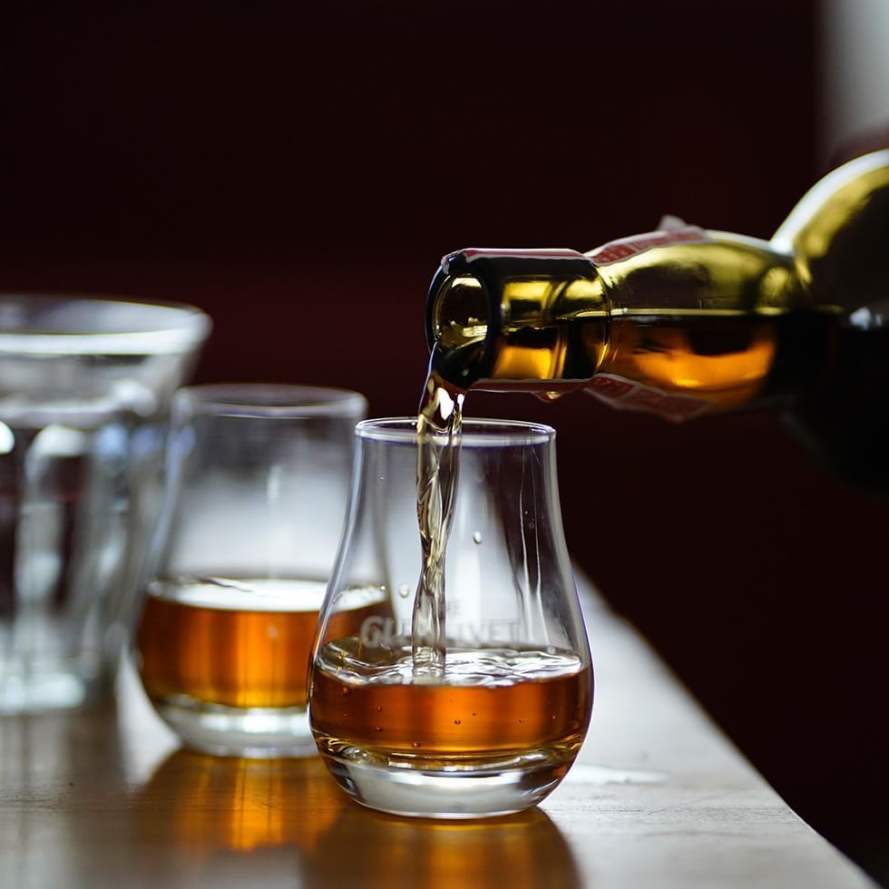 Pouring whisky into glasses in Gölles Schnapps Distillery near Falkensteiner Balance Resort Stegersbach