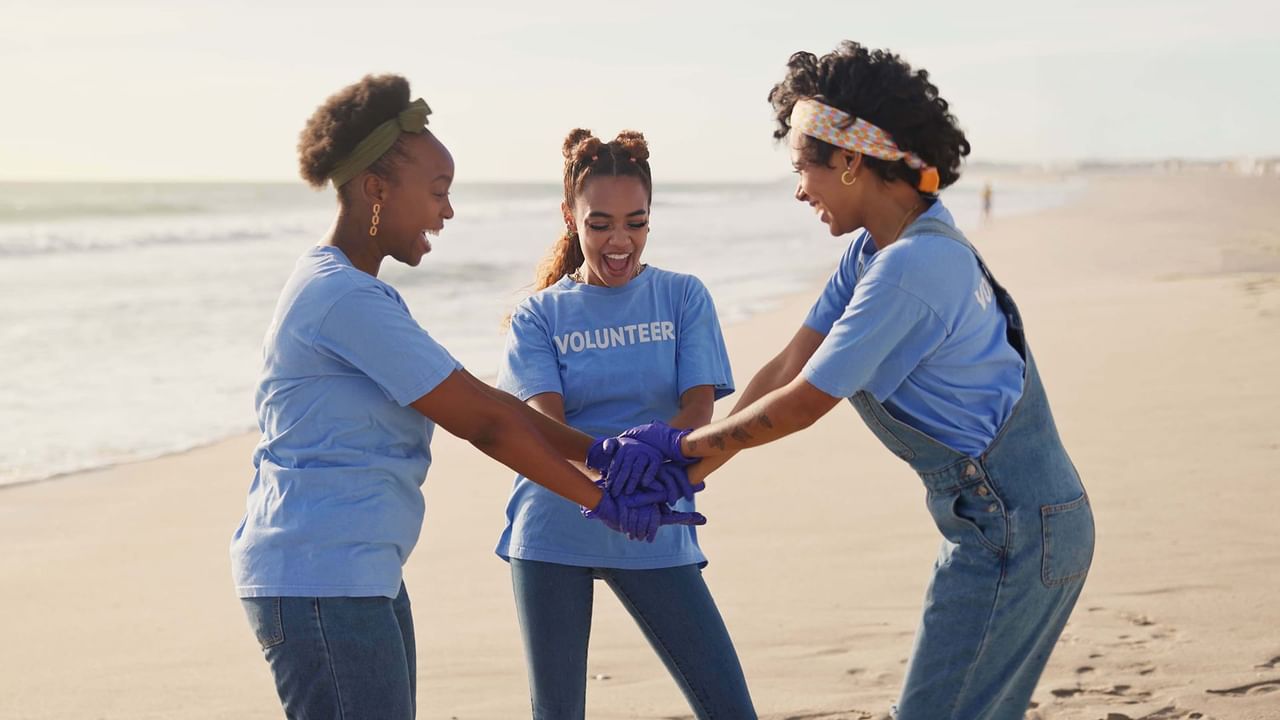 Three women volunteering on a beach