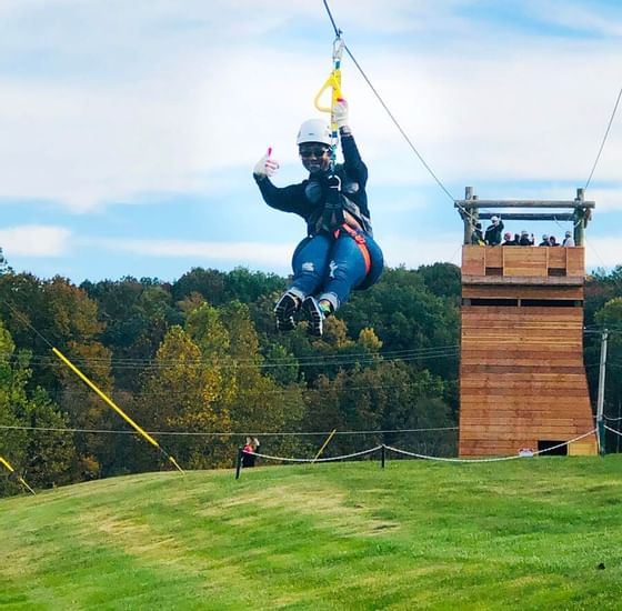 Woman posing while ziplining near Honor’s Haven Retreat