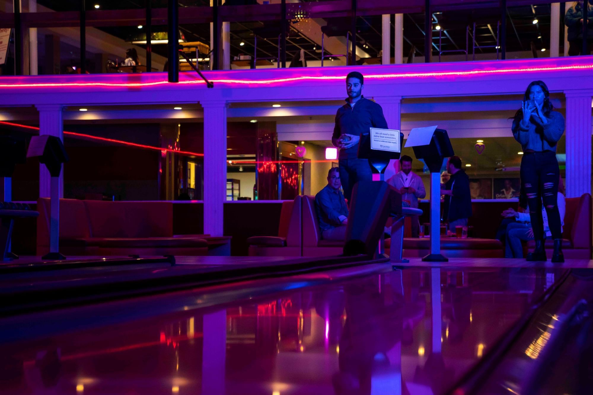 A vibrant bowling alley with colorful neon lights and guests enjoying games at Cove Pocono Resorts