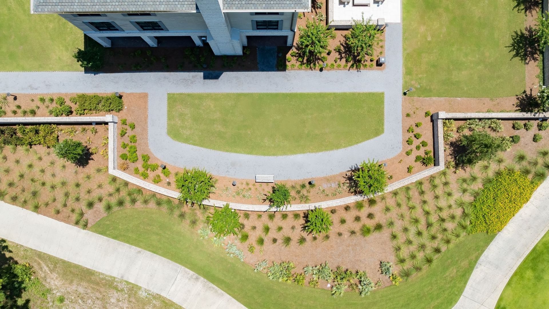 Aerial view of ANR Lawn featuring a curved green space bordered by landscaped beds and pathways at Camp Creek Inn.