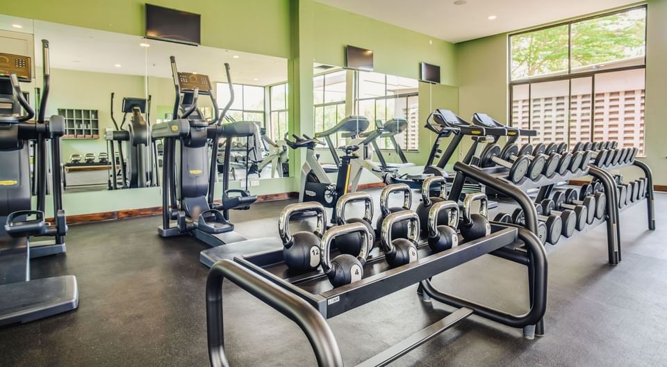 Modern gym with treadmills, weight machines, and kettlebells at Tamarind Tree Hotel