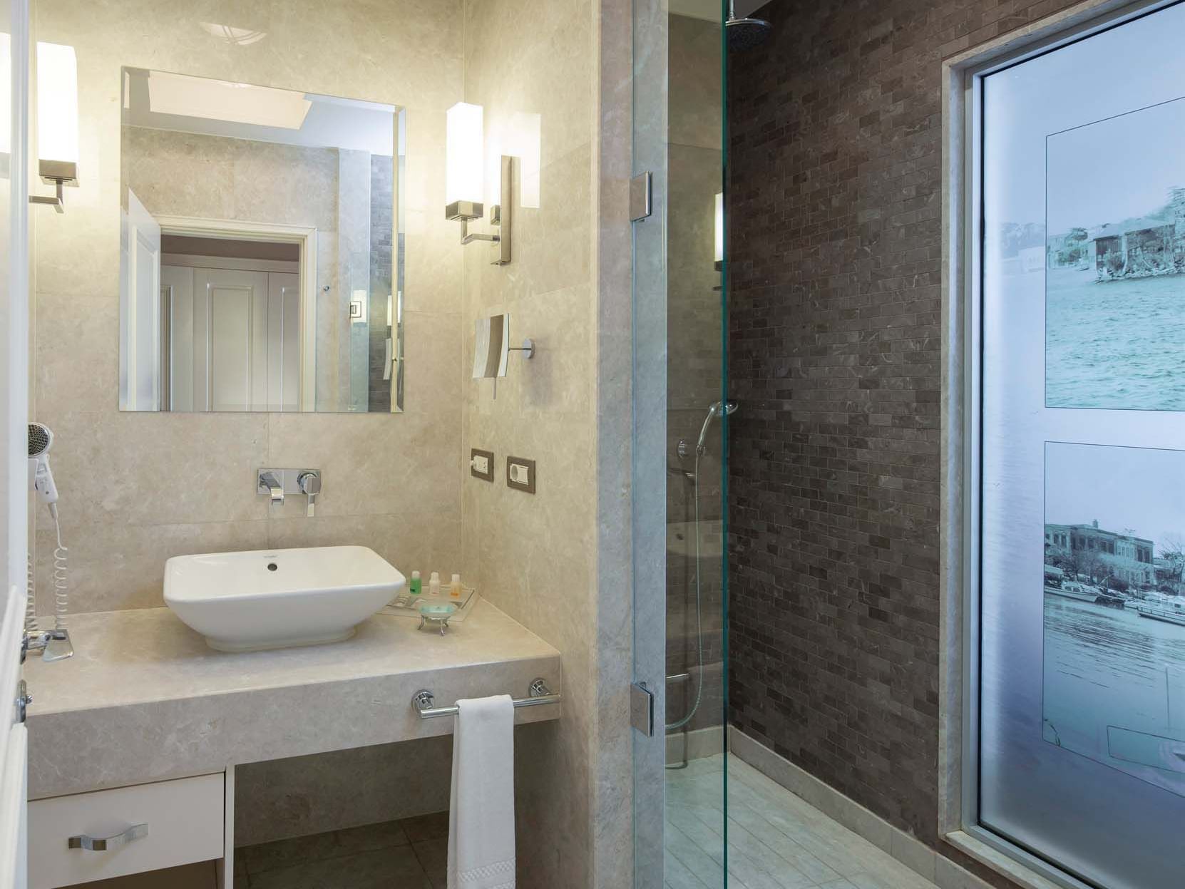 Titanic Business Kartal’ın Deluxe Odasında, şık tasarımlı aynalı banyo dolabı ve modern lavabo ile konforu hissedin