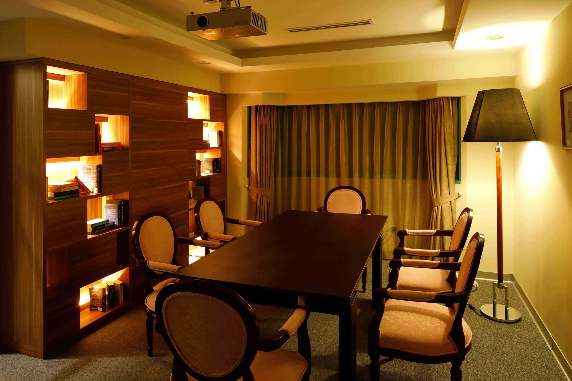 Warmly lit meeting room with a large table, chairs at Sunway Hotel Hanoi