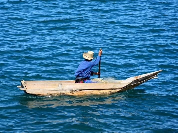 Fisherman sailing in a small boat on the ocean near Porta Hotel del Lago