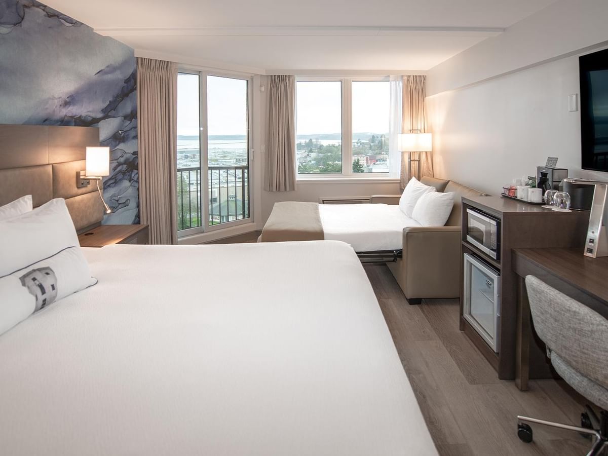 Interior of Coast King room with two beds, a sofa, and a desk at Coast Bastion Hotel in Nanaimo.