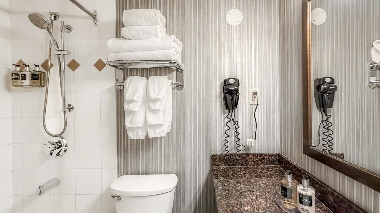 Hotel bathroom with towels, soap and hairdryer 