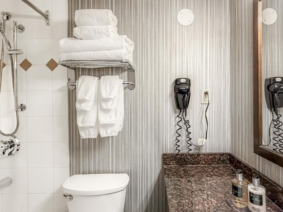 Bathroom with shower, towels, and toiletries.