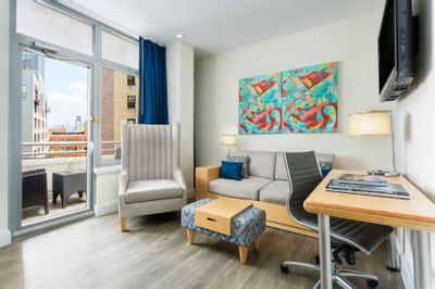 a desk, couch, and chair in a hotel room