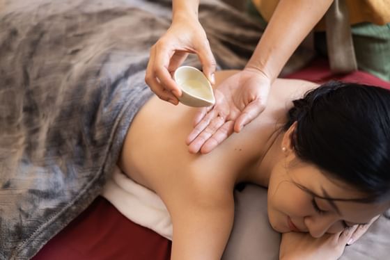 Woman enjoying oil treatment in  Bhu Mhai Spa at Eastin Grand Hotel Phayathai