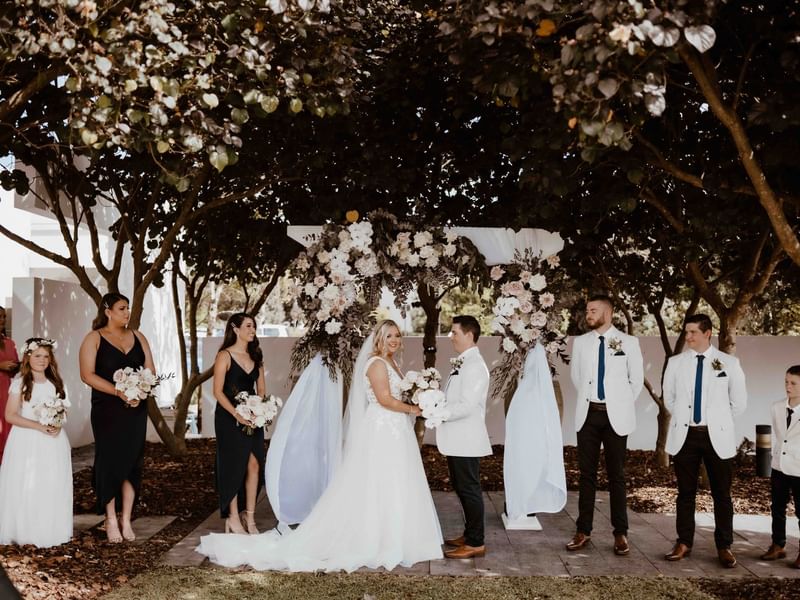 Floral wedding ceremony held outdoors at Pullman Magenta Shores