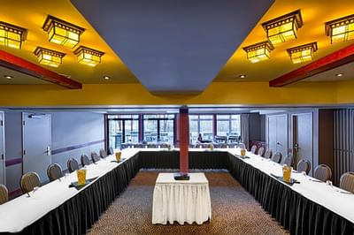 Meeting room with U-shaped table setup and natural light streaming through large windows at Blackstone Mountain Lodge