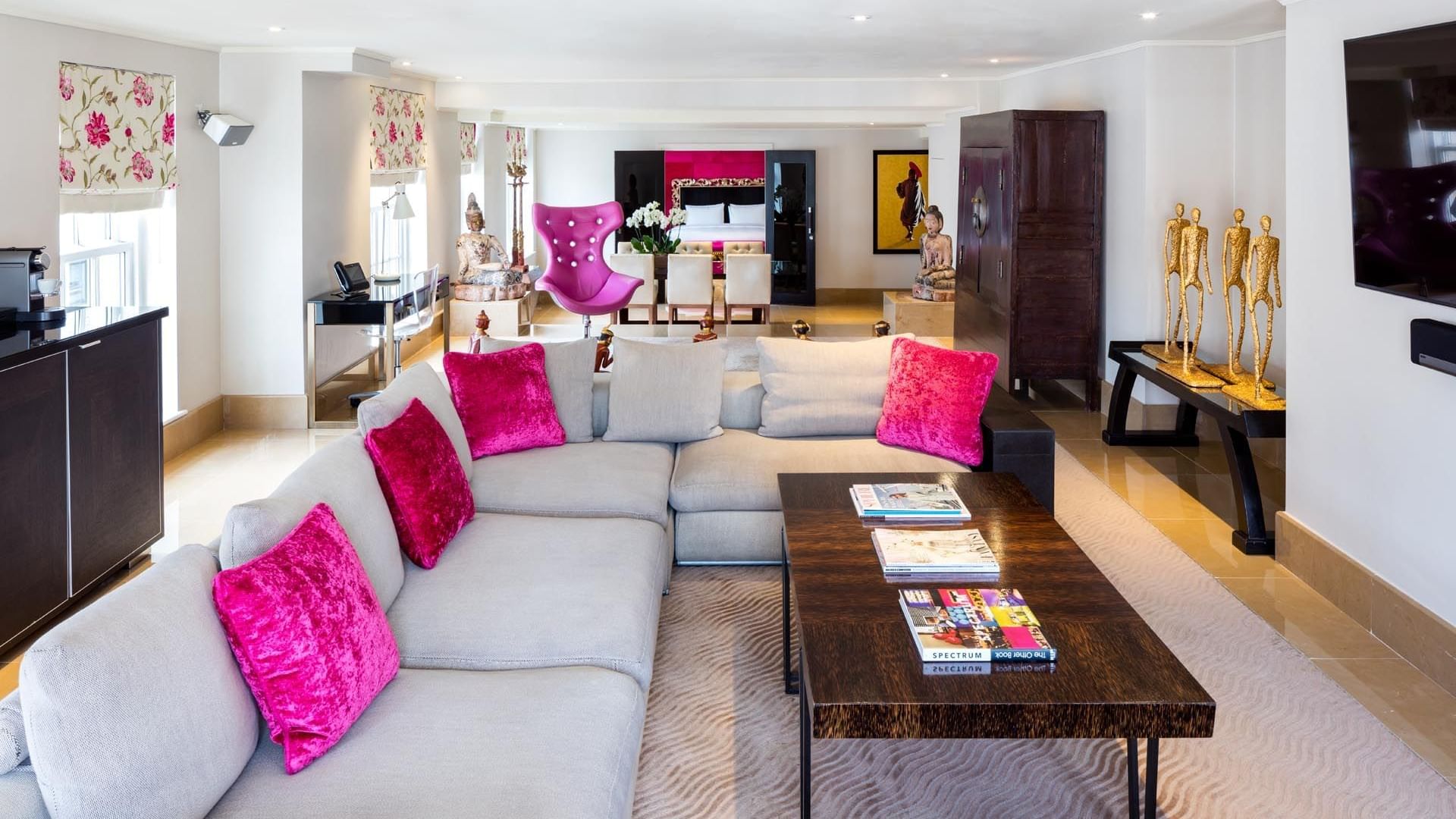 Spacious living room with a gray sectional sofa and coffee table in the Schiaparelli Suite at The May Fair Hotel London