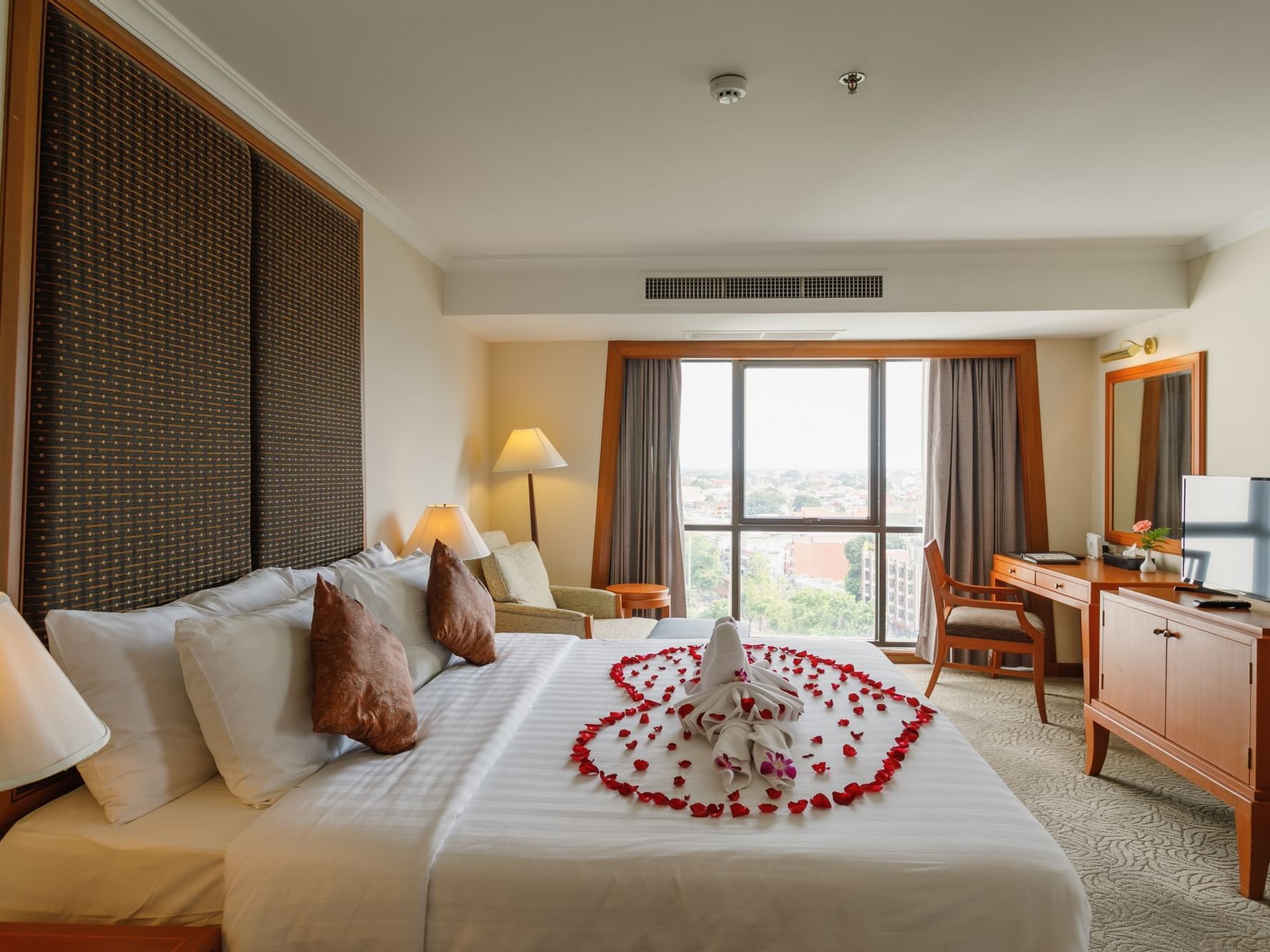 Bed decorated with flowers in Princess Suite at Amora Hotel