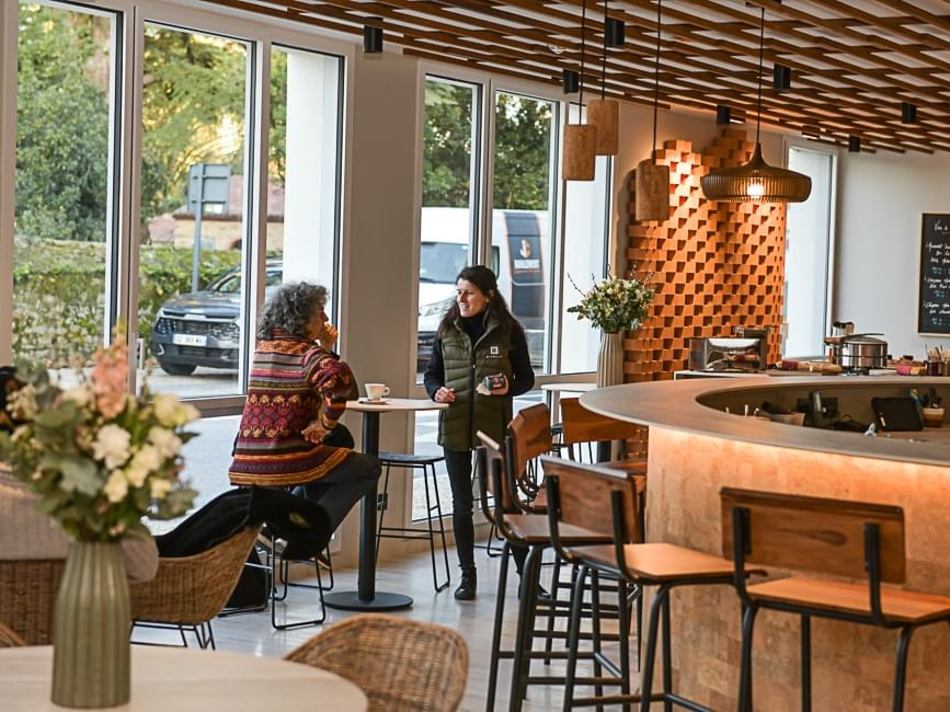 Clients déjeunant dans le salon de thé lumineux de l'Hôtel Rivella.