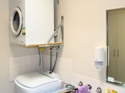 White washing machine and dryer combo in a compact laundry room.