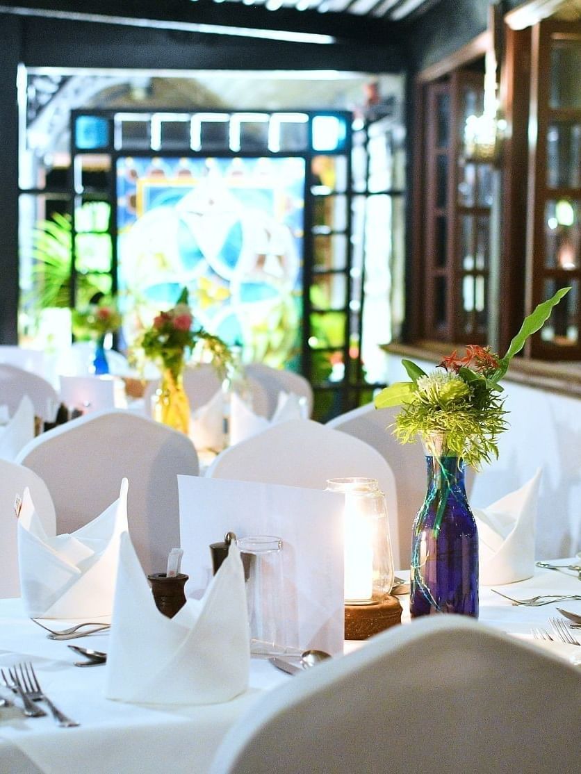 A neatly set table with white napkins and flowers at Fountain in Serena Beach Resort & Spa, Mombasa.