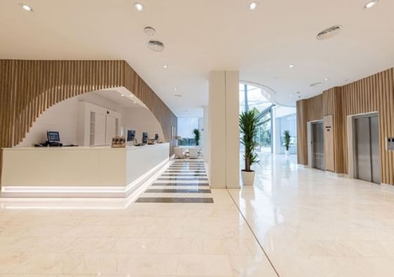 Amplia zona del vestíbulo con un mostrador de recepción en Ponient Hotels