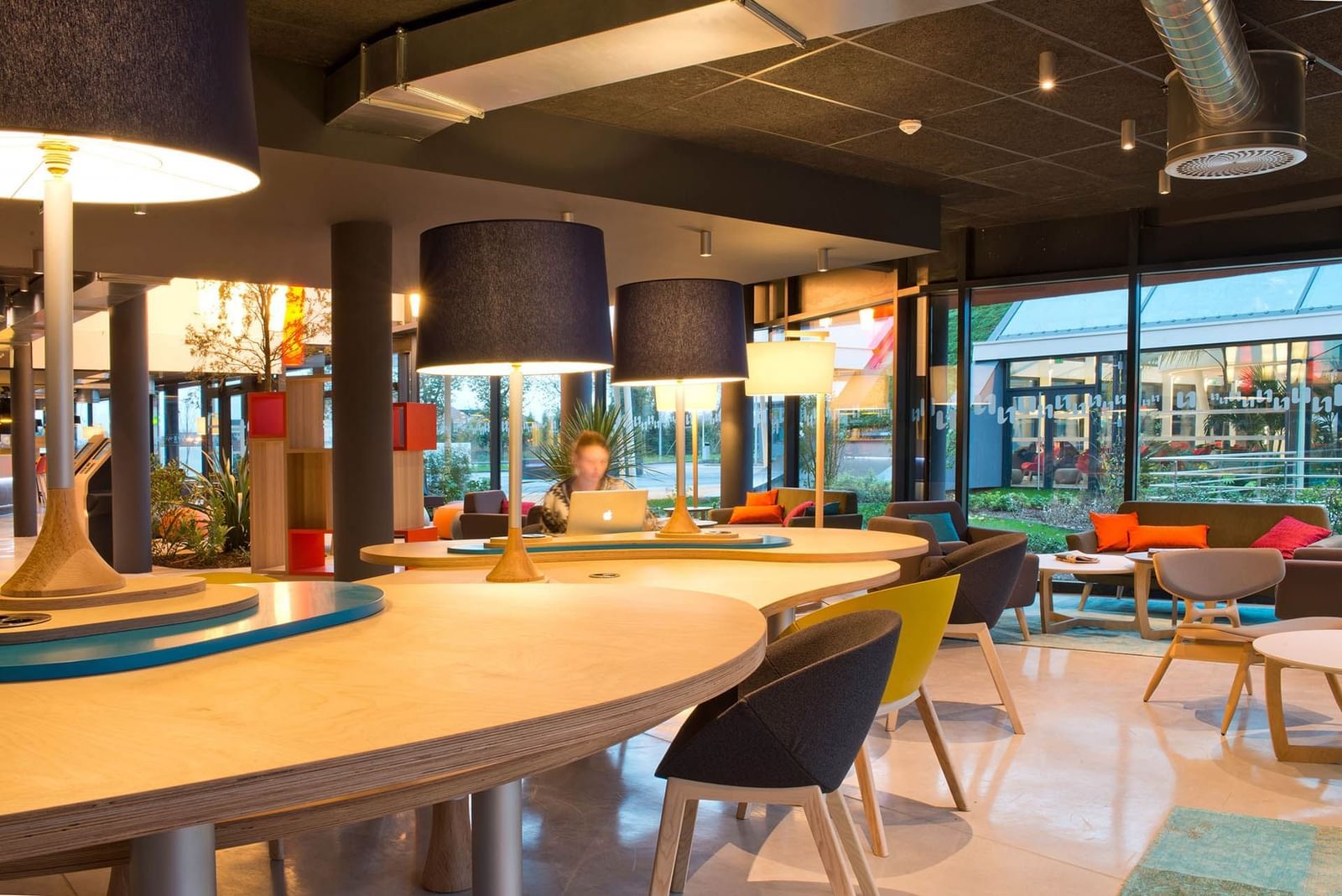 The business corner with modern table and large table lamps at Nomad Hotels Paris Roissy