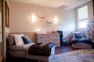 Quiet spa seating area featuring comfortable lounge chairs beside a wooden sideboard at La Tourelle Hotel and Spa