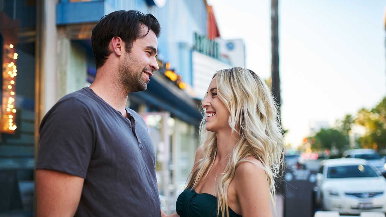 Smiling couple standing together on a vibrant Seattle city street 