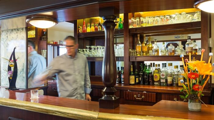 A Bar tender by a Bar counter at Hotel du Chateau
