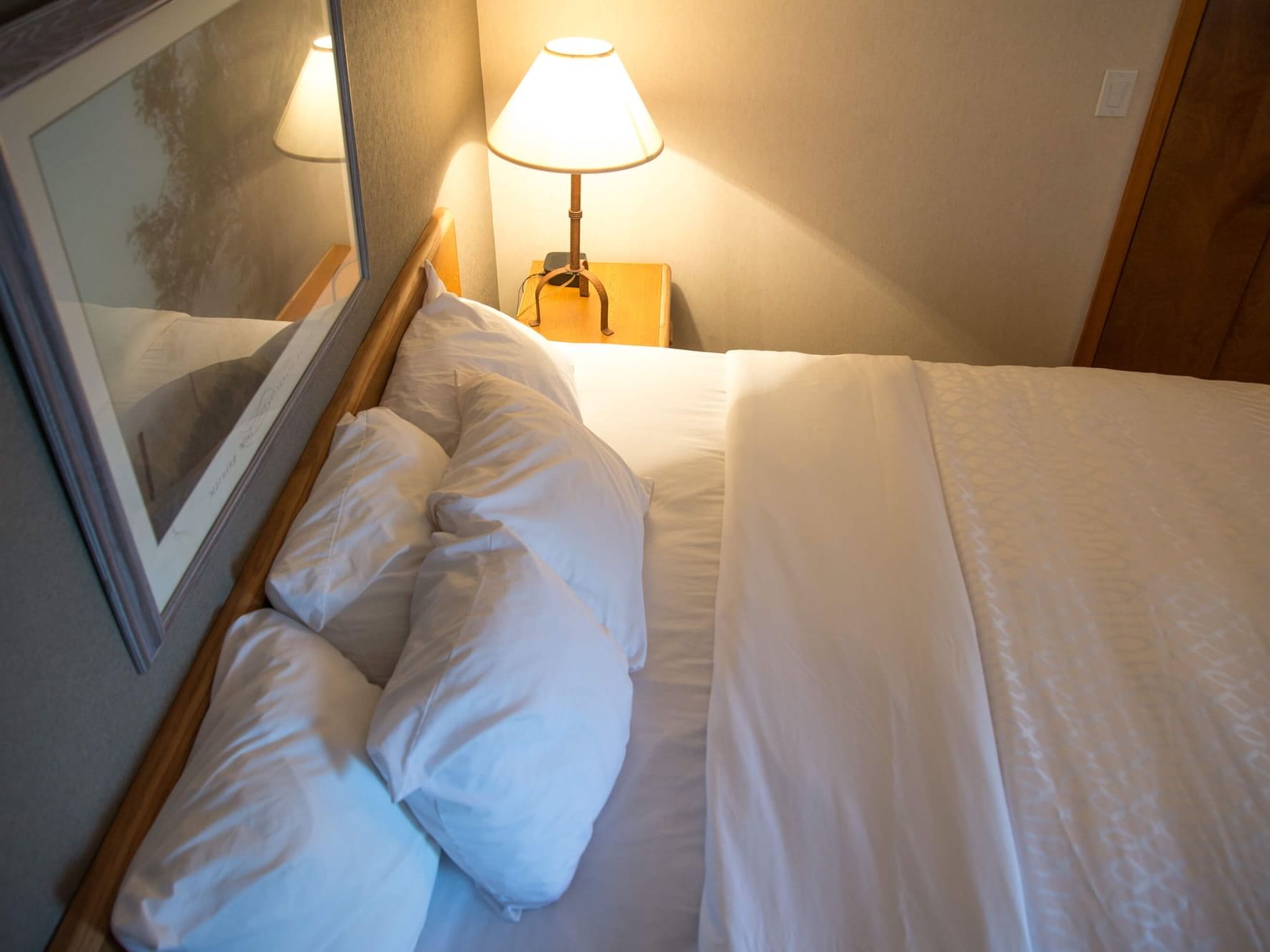 King bed & night lamp in Standard King Room at Evergreen Resort