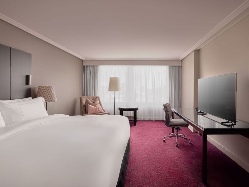 TV and work desk facing the bed in Superior Room at Sofitel Brisbane Central