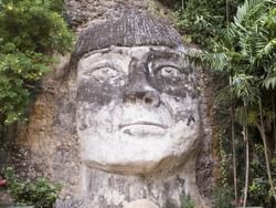 A weathered stone face sculpture, with a flat top, features in Cara del Indio at Royal Isabela, an attraction in Puerto Rico