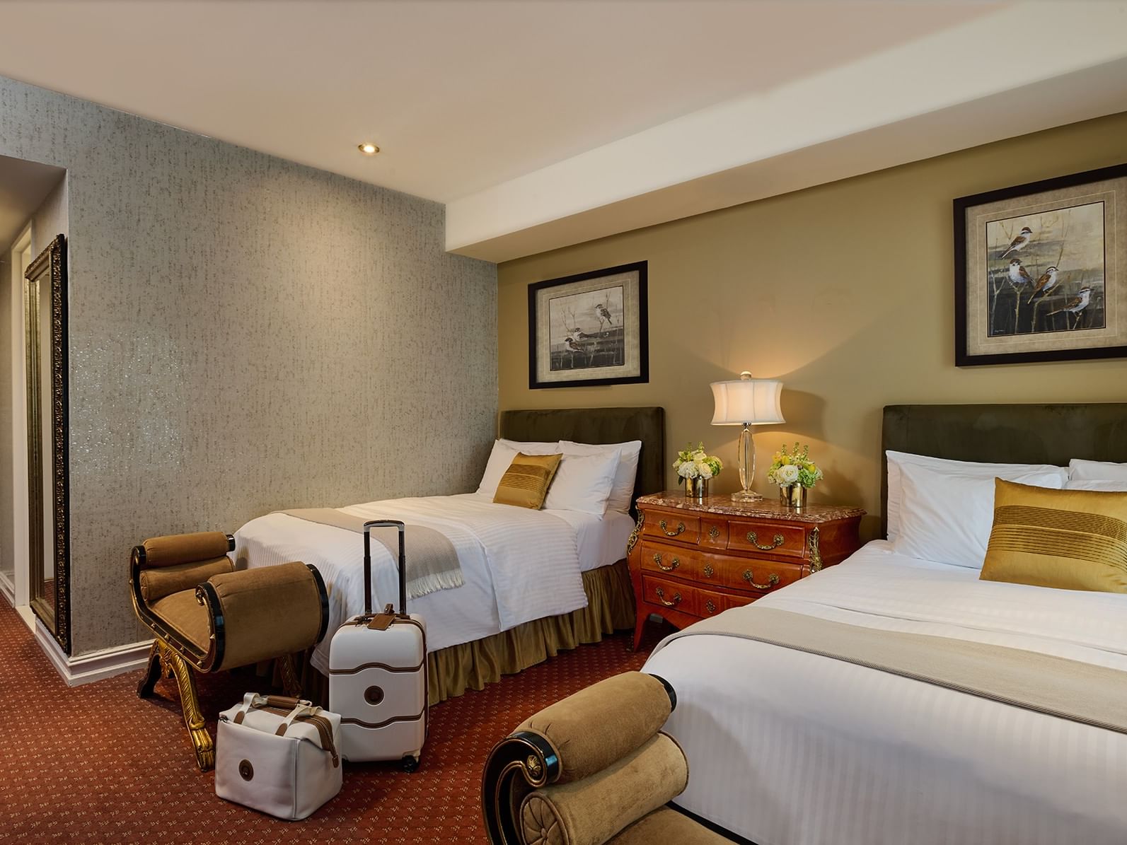 Beds beside nightstand with lamp with bench near luggage in Deluxe Guestroom with Two Double Beds at The Kimberly Hotel