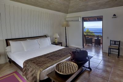 bed in villa with balcony view of ocean