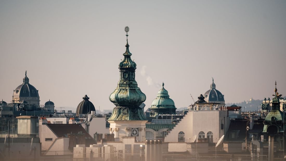 Rooftop view of a cityscape with distinctive architecture and clear skies near Almanac Palais Vienna