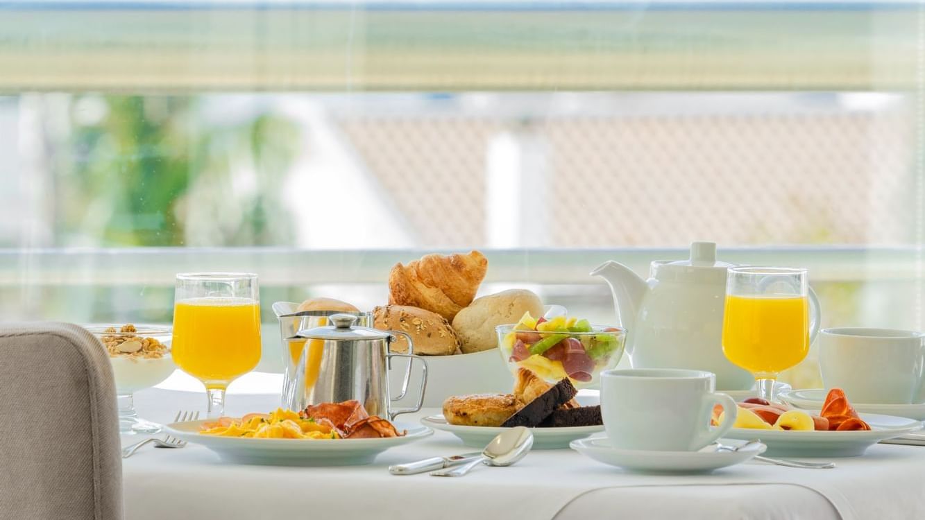 Breakfast meals, bread & fresh juice served on a table in Atlântida Restaurant at São Miguel Park Hotel