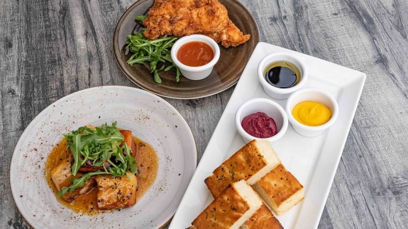 Assorted gourmet dishes with condiments on a wooden table Offering Room service at Mercure Kooindah Waters