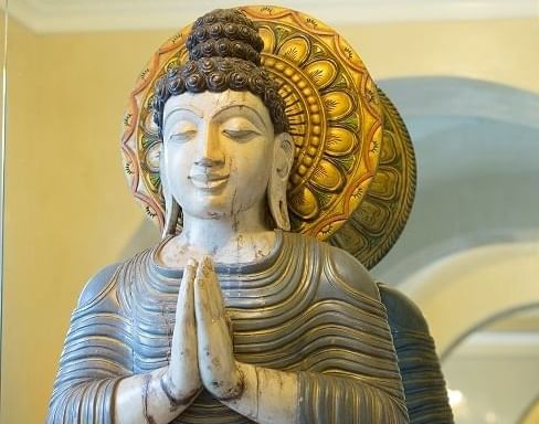 A ancient sculpture of a women praying 