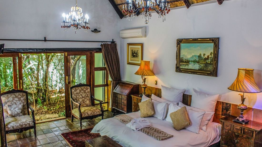 King-size bed by the garden view in Presidential Suite at Kedar Heritage Lodge, Conference Centre & Spa