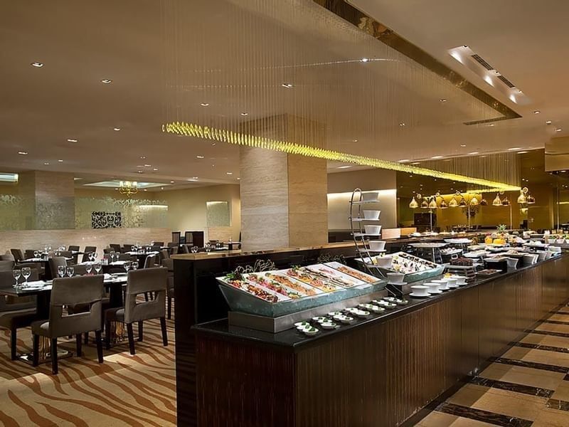 Opened buffet and dining tables arranged in Rainbow Room Coffee Shop at Celebrity International Grand Hotel