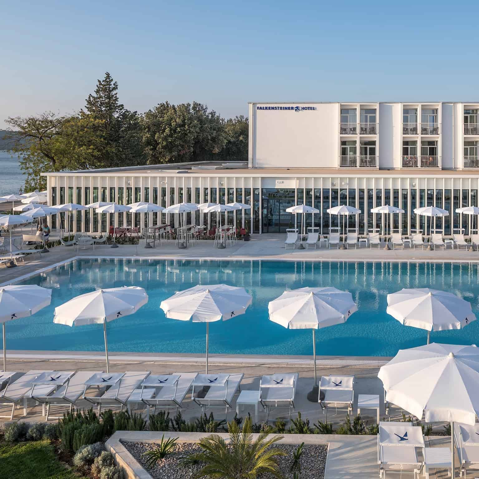 Sunbeds around the outdoor pool at Falkensteiner Hotels