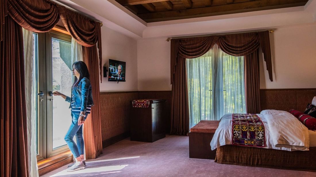 Lady looking by a window in Single Deluxe at Khorog Serena Inn