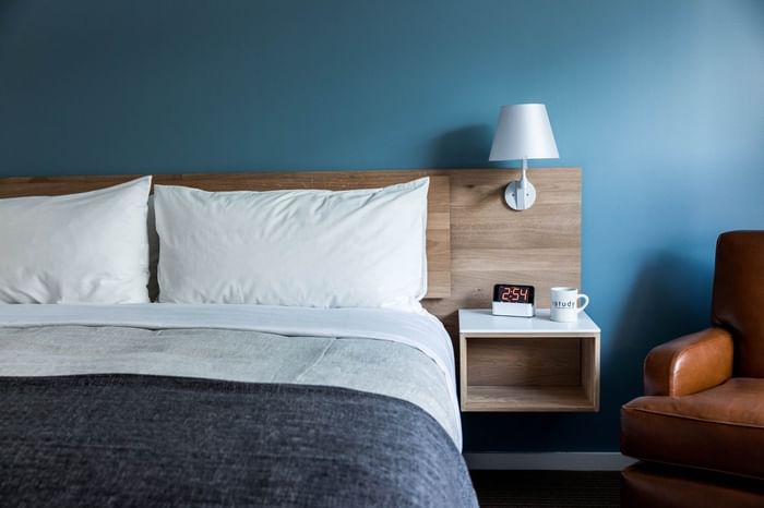 Accessible University Suite with a bedside lamp & nightstand by the bed in The Study at University City