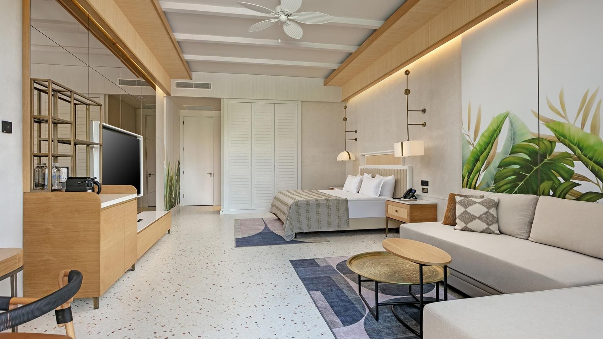 TV & seating area by the cozy bed in Lagoon Golf Swim-up Room at Cullinan Belek